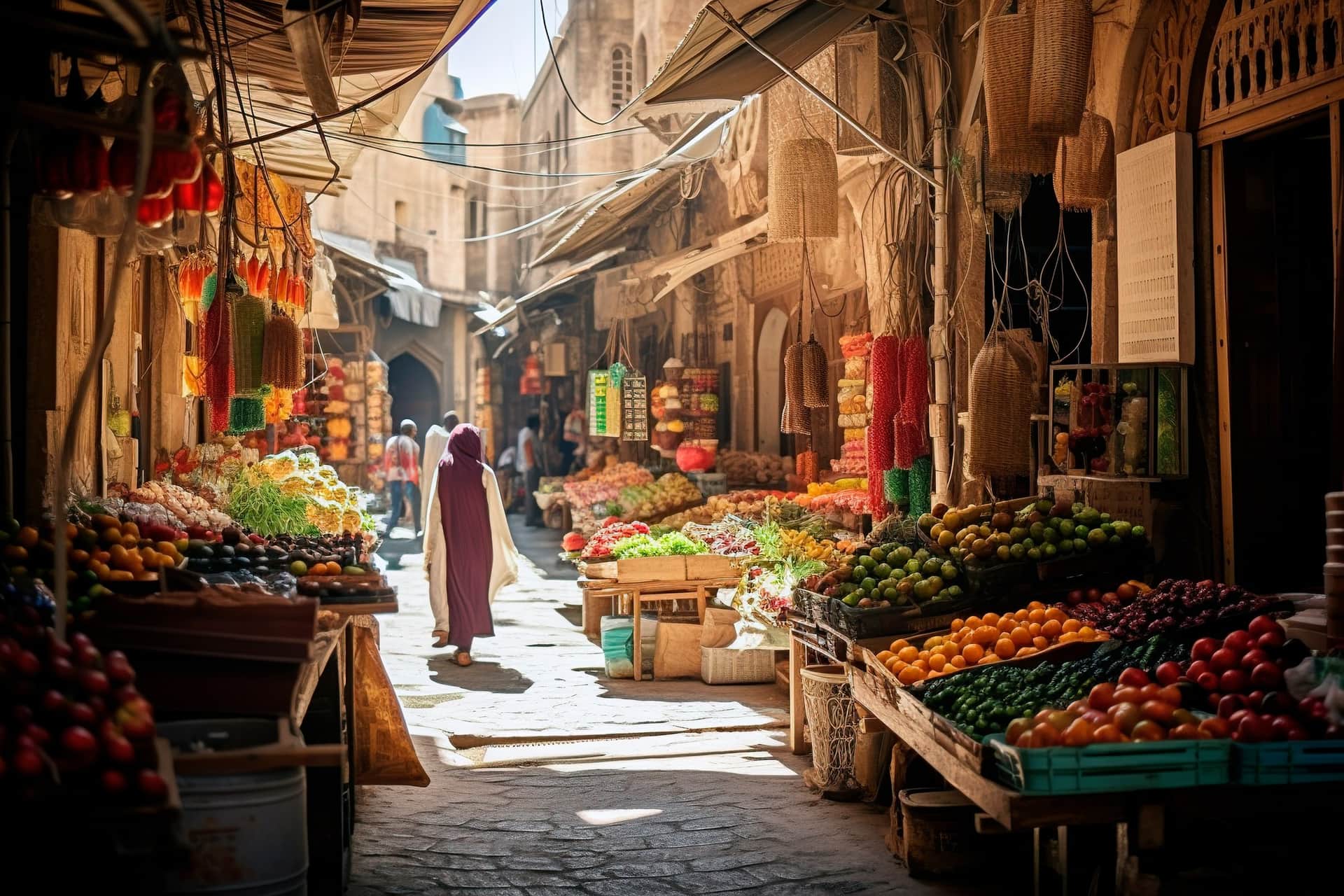 Zoco tradicional marroquí con puestos de frutas y verduras en callejón de medina antigua bajo la luz del sol