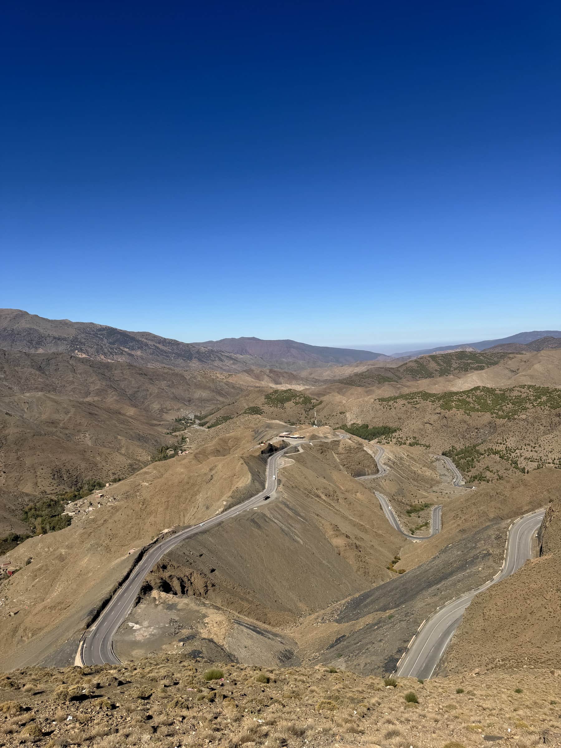 Carretera serpenteante del puerto de Tizi N'Tichka en el Alto Atlas marroquí bajo cielo azul intenso