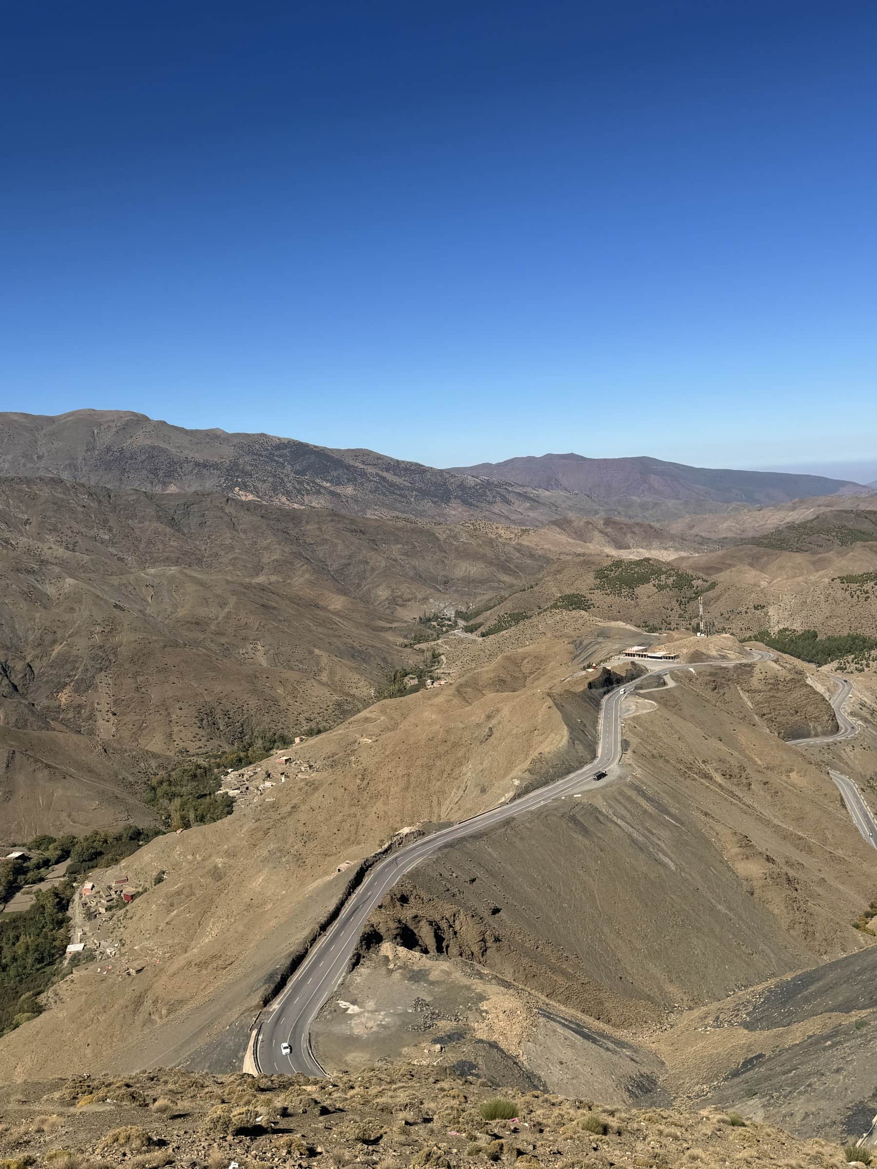 Carretera sinuosa del puerto de Tizi N'Tichka en el Alto Atlas marroquí bajo cielo azul despejado