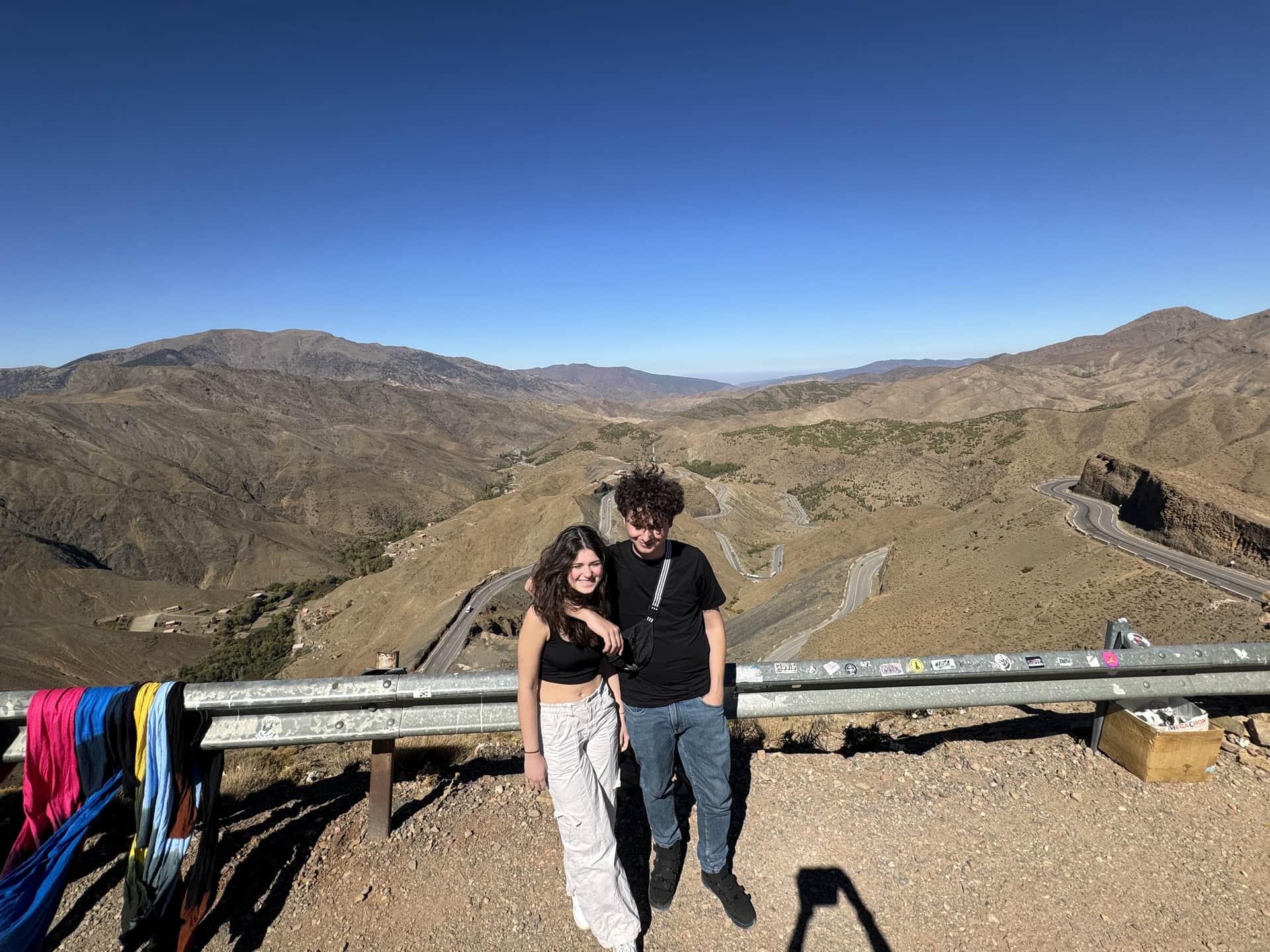 Pareja de jóvenes en el mirador del puerto de Tizi N'tichka con las curvas del Alto Atlas al fondo, Marruecos