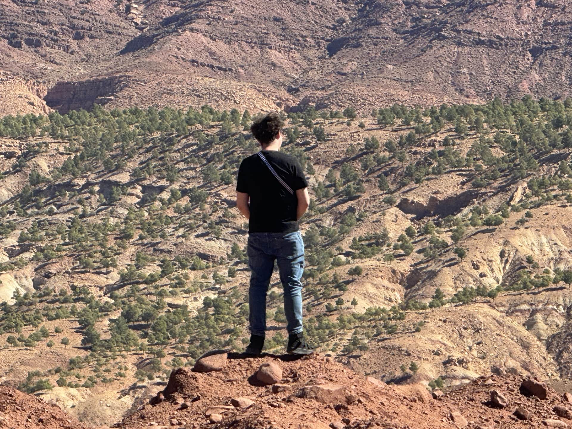 Viajero contemplando el paisaje rocoso y árido de las montañas del Atlas en Marruecos desde un mirador