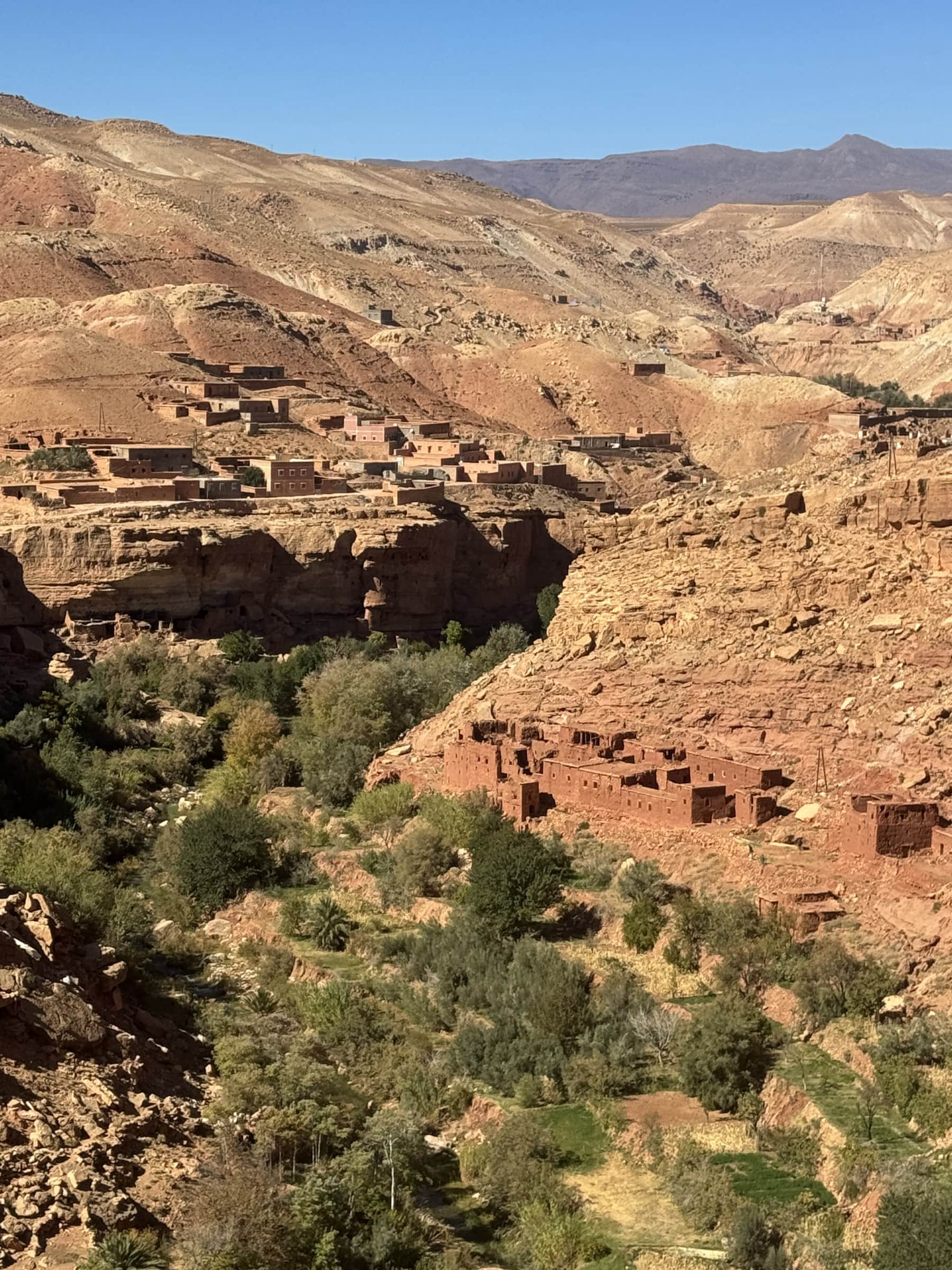 Valle del Dadés con kasbahs de tierra roja entre palmeras y montañas del Atlas al fondo, Marruecos