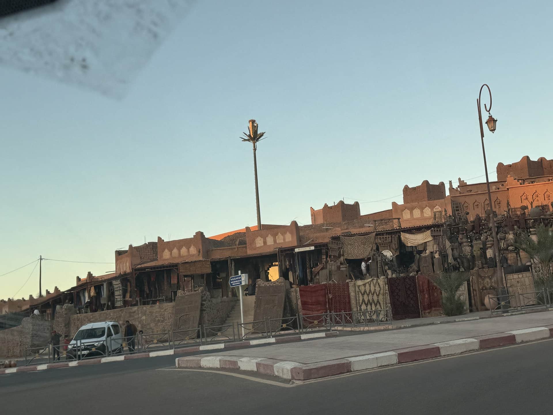 Mercado de artesanía y alfombras en Ouarzazate con arquitectura de adobe al atardecer, Marruecos