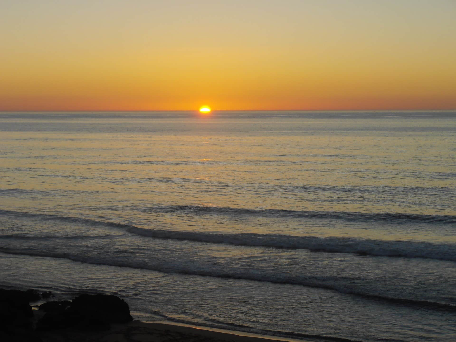 Atardecer sobre el océano Atlántico en la costa de Marruecos, sol tocando el horizonte entre tonos dorados