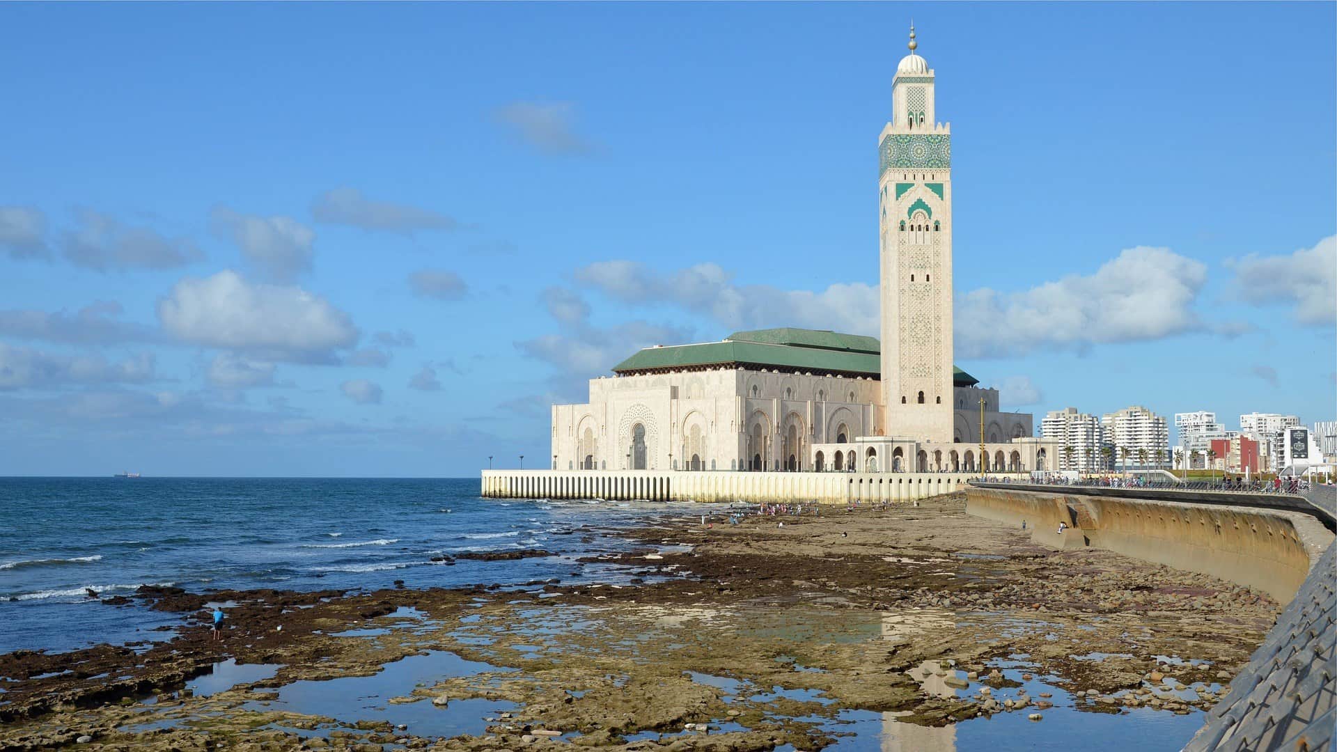 Mezquita Hassan II de Casablanca sobre el Atlántico con su minarete y costa rocosa en primer plano