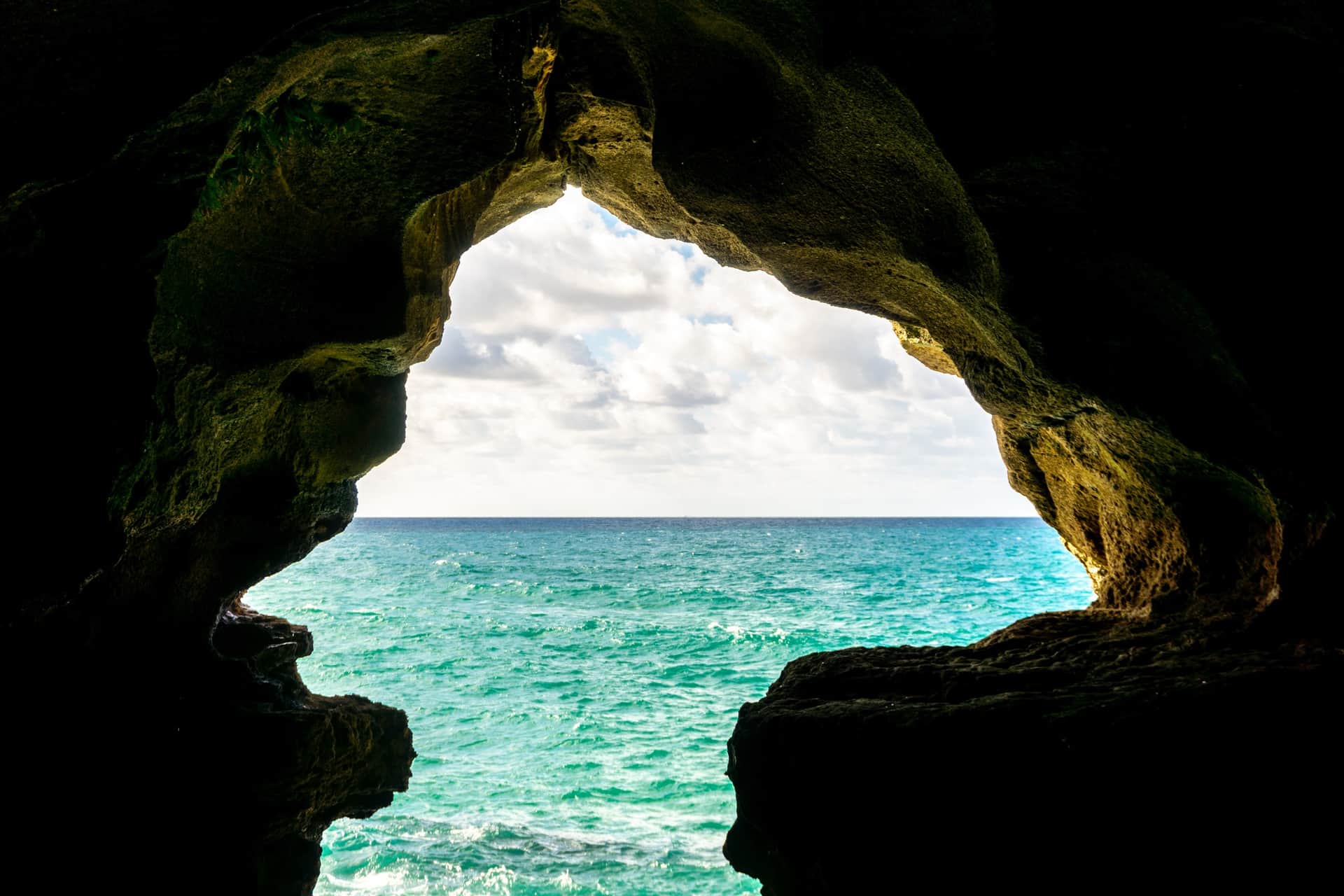 Vista desde el interior de la Cueva de Hércules en Tánger, con arco rocoso enmarcando el Atlántico turquesa