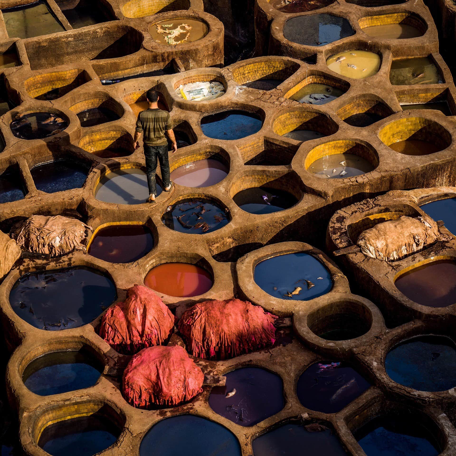 Curtidurías de Chouara en Fez, cubas de tinte multicolor con trabajador entre pieles de cuero, Marruecos