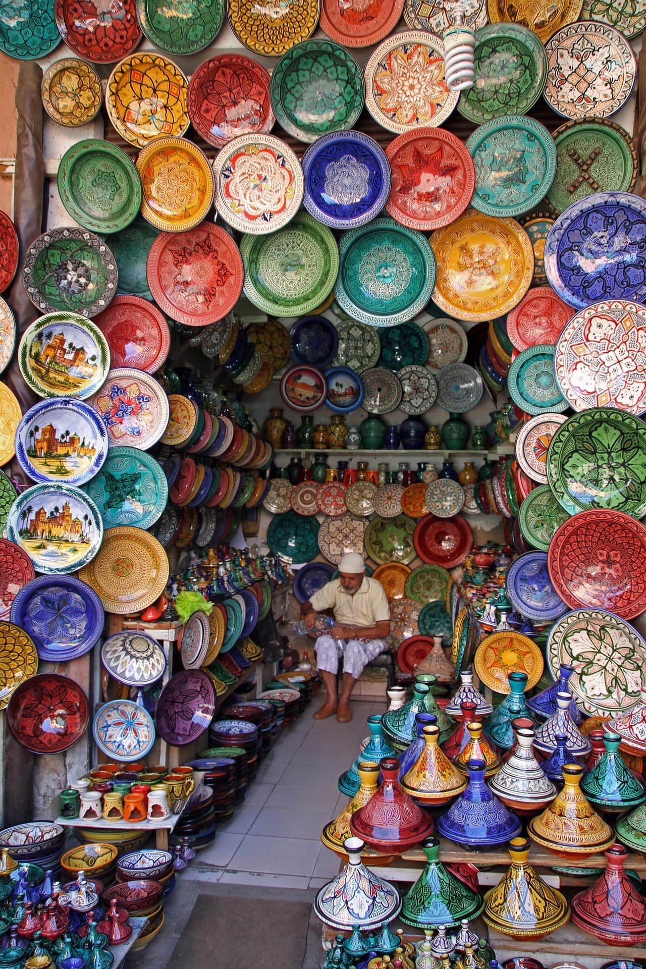 Puesto de cerámica marroquí en el zoco de Marrakech con platos pintados y tajines de colores