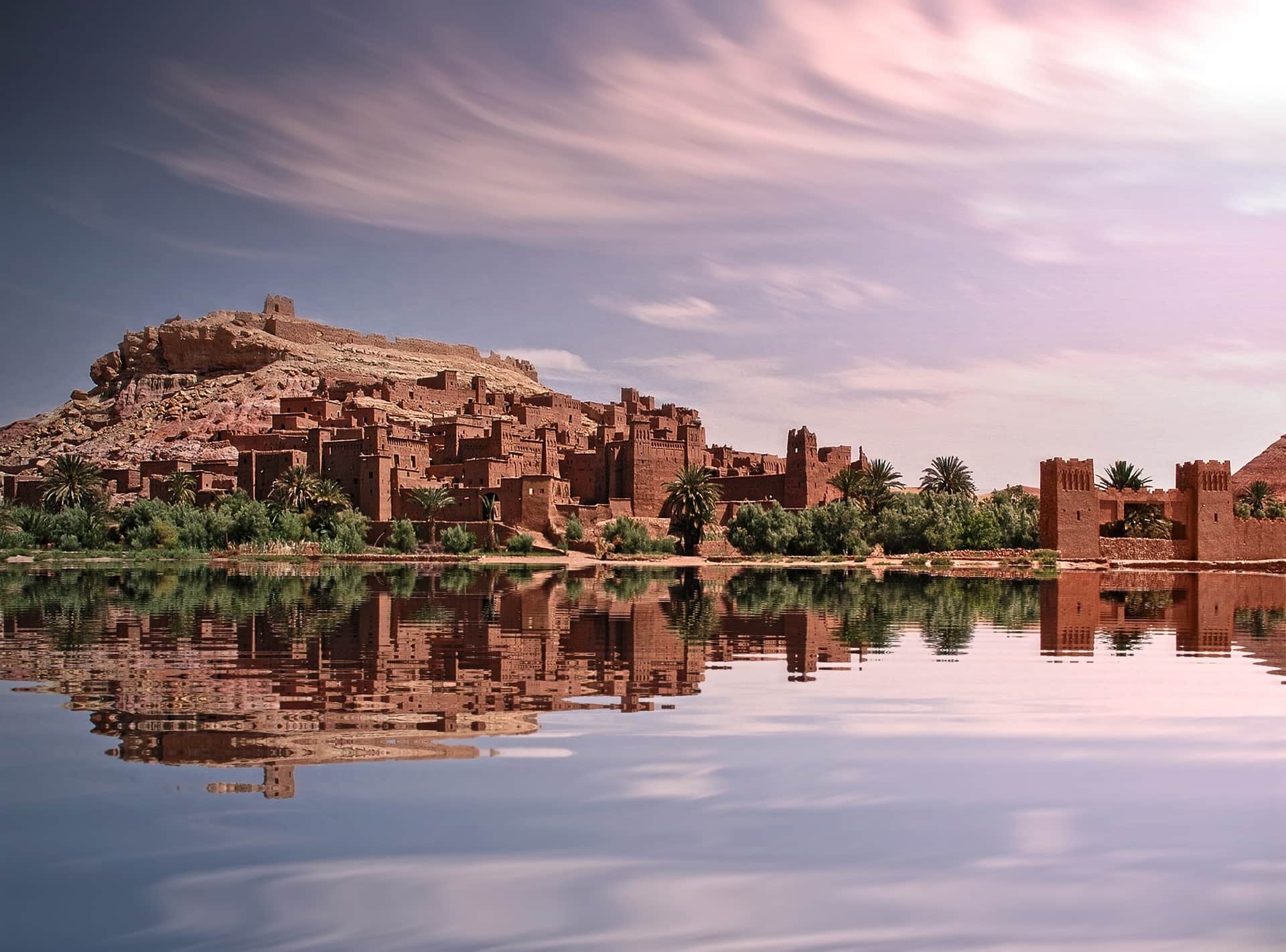 Kasbah de Ait Ben Haddou reflejada en el agua al atardecer, Patrimonio Mundial UNESCO en Marruecos
