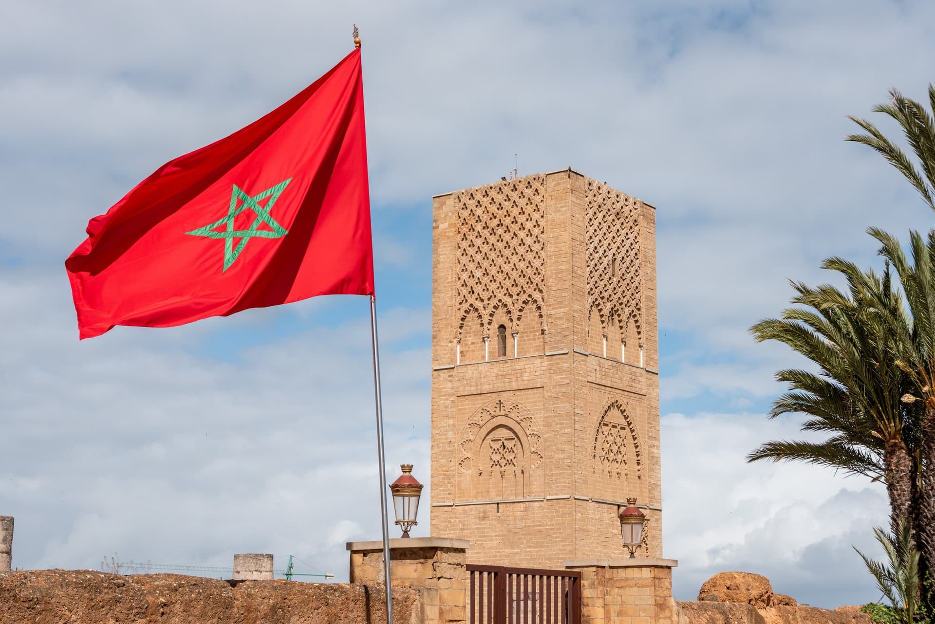 Torre Hassan y bandera de Marruecos en Rabat, minarete almohade del siglo XII con decoración geométrica en piedra
