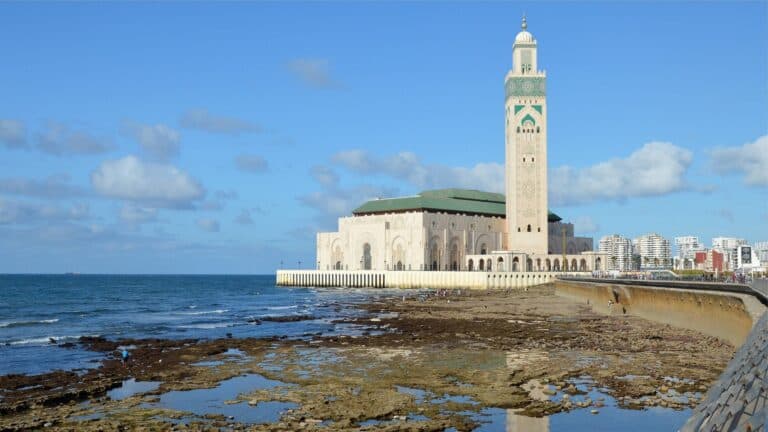 Mezquita Hassan II de Casablanca sobre el Atlántico con su minarete y costa rocosa en primer plano