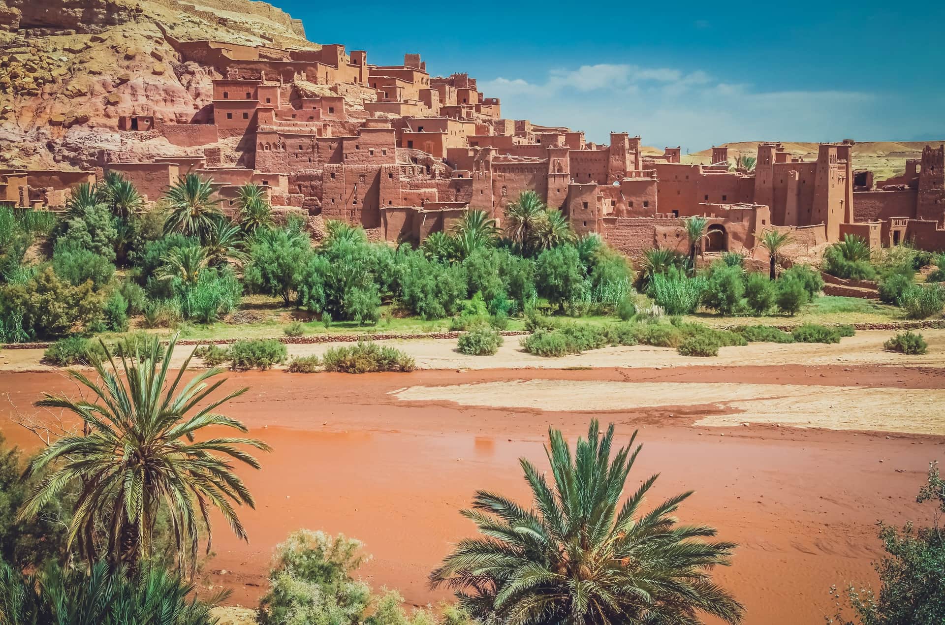Kasbah de Ait Ben Haddou con sus torres de adobe rojo junto al río seco y palmeras, Patrimonio UNESCO de Marruecos