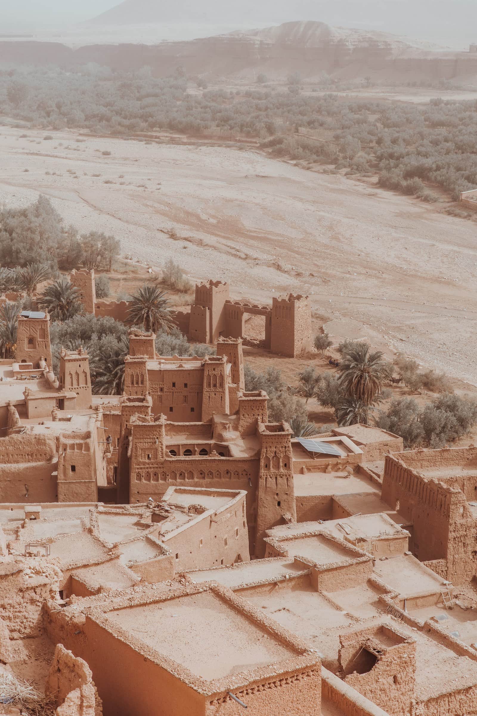 Vista aérea de la kasbah de Aït Ben Haddou, patrimonio UNESCO, con sus torres de barro ocre y palmeras en Marruecos