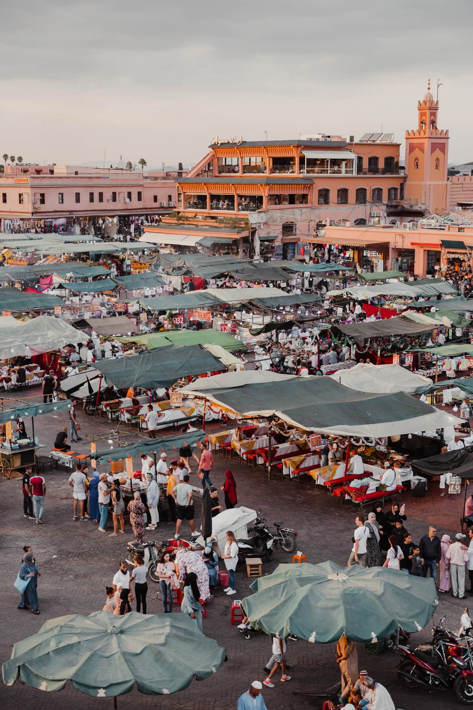 Vista aérea de la plaza Jemaa el-Fna de Marrakech al atardecer con puestos de comida y multitud